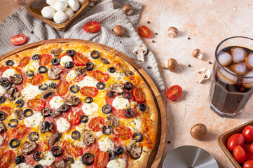 In the photo you see a beautiful still life of pizza, tomatoes, mushrooms. In the right corner of the photo, you also see a pizza cutter. There are no people in the photo. High angle view.