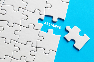 The word alliance written on missing puzzle piece. Teamwork, unity and cooperation