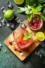 Summer drinks, bar soft beverage. Refreshing glasses drink raspberry with mint lime and ice on a dark stone table. Top view flat lay background. Copy space.