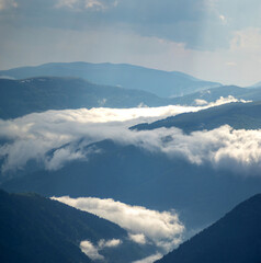 Beautiful panorama of the Carpathian mountains in summer in haze and fog