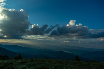 The sun's rays and a beautiful sky at sunset in a mountain village in the Ukrainian Carpathians