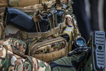 Fototapeta na wymiar Pistol in holster on belt of an armed man.Multicam camouflage. Topic: weapon, armed man, gun, military patrol. Man in camouflage is armed with pistol