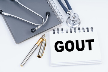 On the table are a stethoscope, a pen and a notebook with the inscription - GOUT