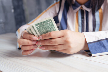 woman counting money in front of the table