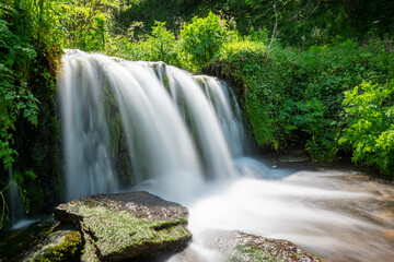 Obraz premium Long exposure of a waterfall flowing onto Lee Abbey Beach in Devon
