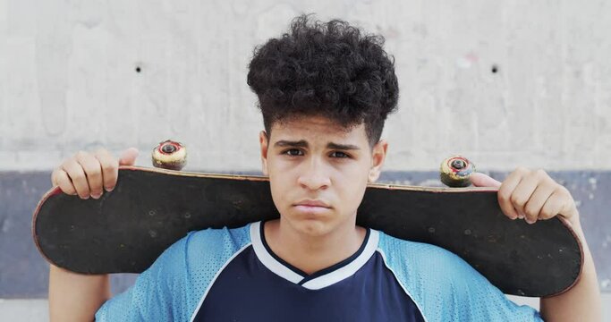 Close-up of an afro teenage boy with the skate in his arms	