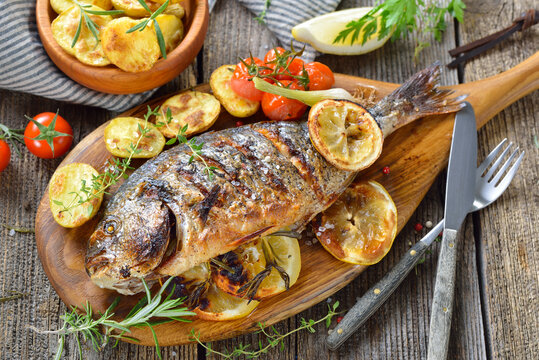 Mediterrane K&uuml;che: Gegrillte Kr&auml;uter-Dorade royal mit Rosmarinkartoffeln &ndash; Mediterranean cuisine: Grilled gilthead sea bream with herbs, lemon slices and rosemary potatoes 