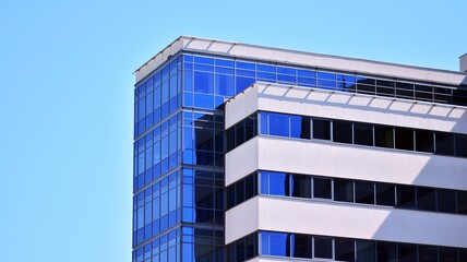 Glass facade of the buildings with a blue sky. Modern building in the business city center. Background of modern glass buildings. 