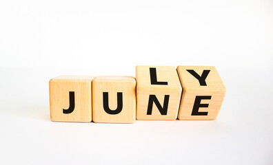 From june to july symbol. Turned wooden cubes and changed the word 'june' to 'july'. Beautiful white background, copy space. Business and from june to july concept.