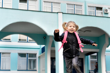 Happy little blonde girl flees school, concept of training preschoolers