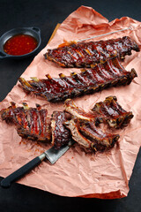 Barbecue pork spare loin ribs St Louis cut with hot honey chili marinade served as close-up on butcher paper