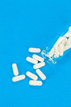 Set of pills on cristal jar for vaccines on coloured background