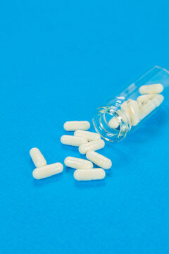 Set of pills on cristal jar for vaccines on coloured background