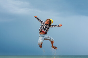 Joyful boy fun jumping on the background of the sea. Travel concept. End of quarantine of coronavirus covid-19. Travel and beach holiday. Vacation. Summer rest