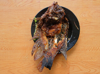 Close up detail of grilled fish dish. Fish spines on the plate, dirty plate with leftover grilled fish