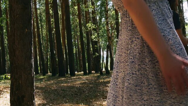 A sweet lady in a summer light dress in an unusually beautiful forest filled with life relaxes with dancing movements. Woman relax in dance, moving smoothly.