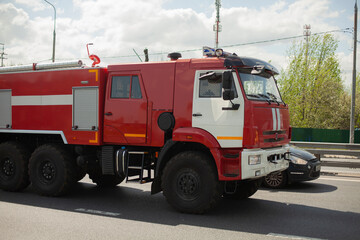 Fire truck on the road. The car goes to extinguish the fire.