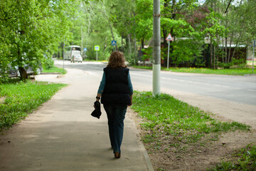 A woman walks through the park. The woman returns home on the way.