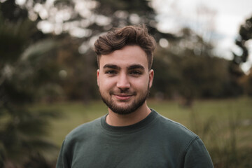 Portrait of a young handsome Caucasian man in a park