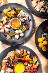 A table served in a restaurant, many different dishes and drinks on one table for a large company.