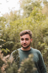 Portrait of a young handsome Caucasian man in a park