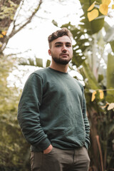 Portrait of a young handsome Caucasian man in a park