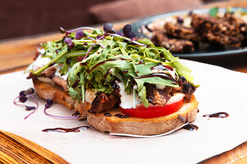 Bruschetta ribeye with dor blue cheese, herbs and fresh tomatoes on a table in a restaurant.