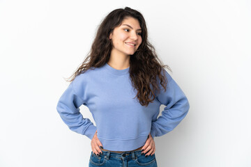 Teenager Russian girl isolated on white background posing with arms at hip and smiling
