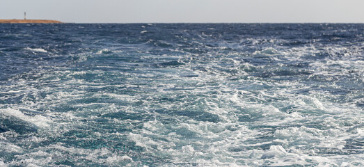 Turbulent flow of a boat wake. Sea wave. The yacht sails, leaving behind a trail and waves.