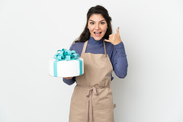 Pastry Russian chef holding a big cake isolated on white background making phone gesture. Call me back sign