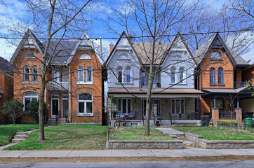 Residential street with tall narrow Victorian style semi-detached houses with gables