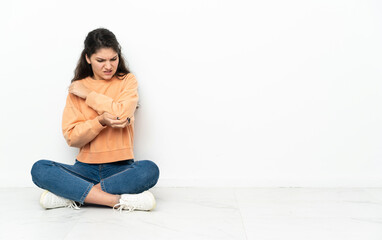 Teenager Russian girl sitting on the floor with pain in elbow
