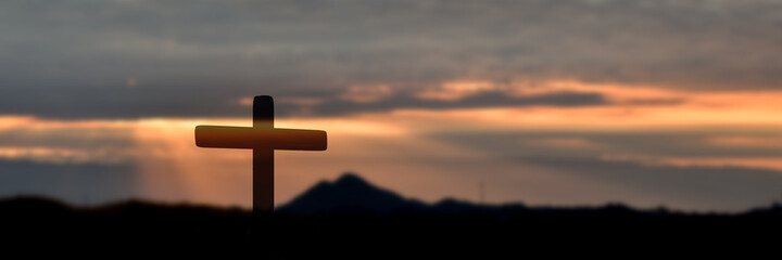 Silhouette of catholic cross at sunset background. panorama picture