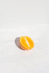 Orange half on marble background. Editorial still life.