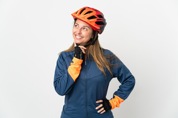 Middle age cyclist woman isolated on white background thinking an idea while looking up