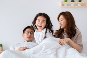 Fototapeta premium Happy Asian family spending a time together in bedroom.