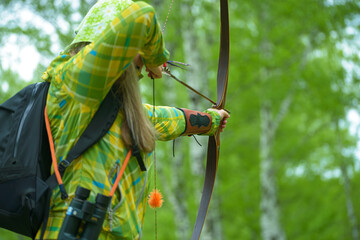 professional archers shooting with modern longbows at meadow