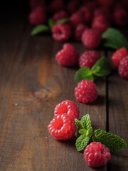 Raspberry berries and peppermint on a wooden table. Copy space.