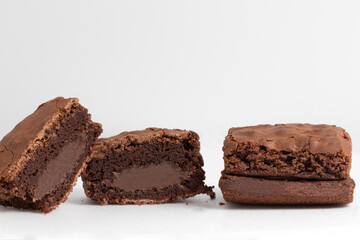 Whole and halves brownies stuffed with chocolate on white background.