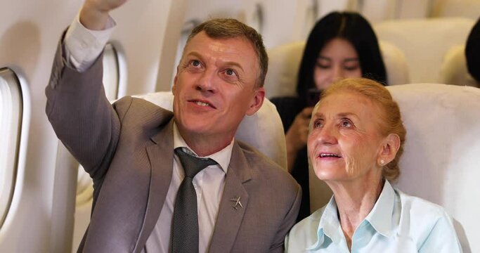 Happy Senior business man and mother passenger make selfie photo sitting in comfortable business class seat. Family travel together