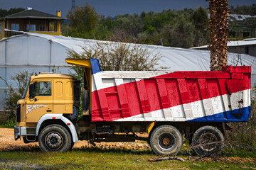 Dump truck with the image of the national flag of Costa Rica is parked against the background of...