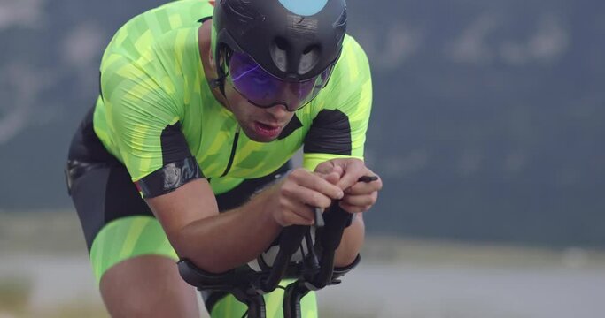 Closeup shot of triathlon sportsman athlete cyclist riding professional racing bicycle.