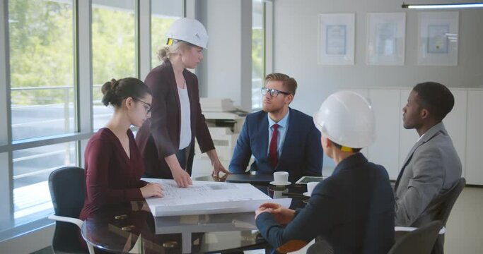 Team of diverse male and female engineers and architects discussing construction plans