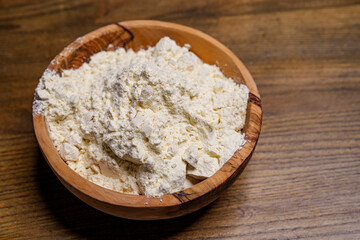 flour in a wooden dish on the kitchen table. 
