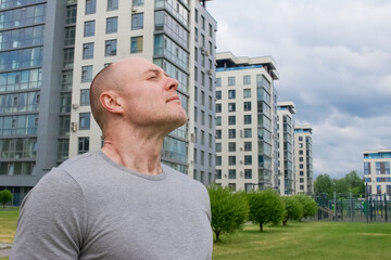 Empty space for text. Sporty man 45-50 breathes fresh air in the city