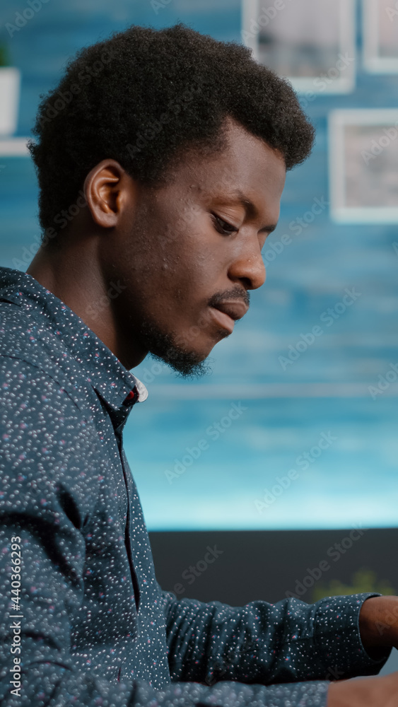 Poster selective focus on african american man working from home, taking notes on notepad while remote work