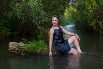 Fototapeta premium woman in a dark dress in the river