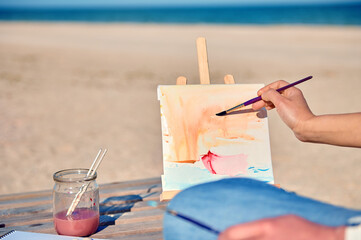 Focus on painting on canvas on the sea background. Hobby concepts . Open air