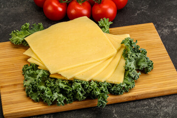 Sliced Gauda cheese over board