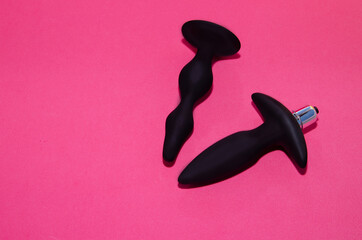 Toys for sex. Anal dildos on a pink background. Space for text